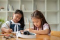 A pretty Asian elementary school girl is focusing on studying, writing, or drawing on paper Royalty Free Stock Photo