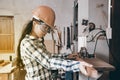 Pretty Asian female carpenter using Electric Sander for wood.