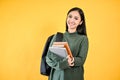 A pretty Asian female college student in a cozy sweater with her backpack holding her books Royalty Free Stock Photo