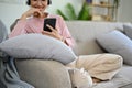 Pretty Asian female enjoys listening to music through her headphones in the living room. cropped Royalty Free Stock Photo