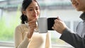 Pretty Asian female office employee enjoys a coffee break with her boyfriend. close-up