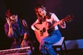 Pretty Asian female singer playing acoustic guitar with male playing electric keyboard. Recording songs by using a studio Royalty Free Stock Photo