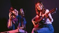 Pretty Asian female singer playing acoustic guitar with male playing electric keyboard. Recording songs by using a studio Royalty Free Stock Photo