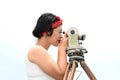 Pretty Asian female surveyor or engineer worker working with theodolite equipment at outdoor.