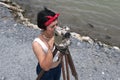 Pretty Asian female surveyor or engineer worker working with theodolite transit equipment.