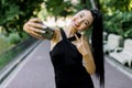 Pretty Asian funny laughing girl with beautiful nude make up and ponytail hair style, showing V sign while taking selfie Royalty Free Stock Photo