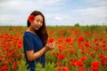 Pretty asian girl with long hair in blue dress in field of poppy seed flower on green stem on natural background, summer Royalty Free Stock Photo