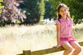 Pretty Asian Girl Sitting On Fence In Countryside Royalty Free Stock Photo