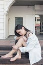 Pretty asian girl sitting on a public bench