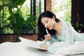 Pretty asian girl working on her school project at home Royalty Free Stock Photo