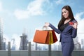 Pretty asian lady with shopping bags showing credit card Royalty Free Stock Photo