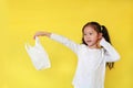 Pretty asian little girl needless a white thin polythene plastic bag for Reduce or zero waste. Kid holding a plastic bag isolated