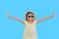 Pretty asian little girl wearing a sunglasses and straw hat with open wide arms isolated on light blue background with clipping Royalty Free Stock Photo