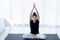 Pretty Asian middle-ages women are practicing yoga in the basic position in her bedroom