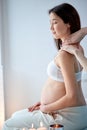 Pretty asian pregnant female getting spa massage on back, hugging tummy Royalty Free Stock Photo