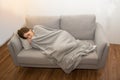 Asian Sick woman covered with a blanket lying in bed with high fever and a flu Royalty Free Stock Photo