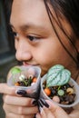 Pretty Asian Teen Girl Holding Baby Tropical Plants