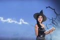 Pretty asian witch woman wearing hat and using her spell