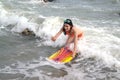 Pretty Asian woman in bikini with surf board on fun.