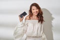 Pretty asian woman in casual wear holding smartphone in one hand, dancing