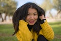Pretty Asian woman in city park - lifestyle portrait of young beautiful and happy Chinese girl sitting on green grass cheerful and Royalty Free Stock Photo