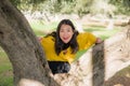 Pretty Asian woman in city park - lifestyle portrait of young beautiful and happy Japanese girl playful by a tree enjoying Royalty Free Stock Photo