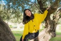 Pretty Asian woman in city park - lifestyle portrait of young beautiful and happy Japanese girl playful by a tree enjoying Royalty Free Stock Photo