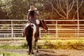 Pretty Asian woman cowgirl riding a horse outdoors in a farm. Royalty Free Stock Photo