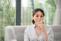 Pretty asian woman drinking water on couch at home in the living room Royalty Free Stock Photo