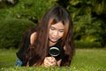 Pretty Asian woman with magnifying glass . Royalty Free Stock Photo