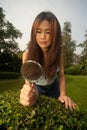 Pretty Asian woman with magnifying glass . Royalty Free Stock Photo