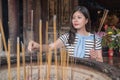 Pretty asian woman offering incense to gods. Royalty Free Stock Photo