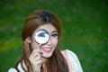 Pretty Asian woman posing with magnifying glass . Royalty Free Stock Photo