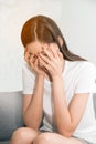 Asian woman with severe migraine headache holding hands to head in a room. Royalty Free Stock Photo