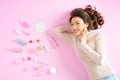 Pretty Asian woman smiling while lying on pink floor with her cosmetic makeup tools. Top view Royalty Free Stock Photo