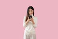 A pretty Asian woman is using her smartphone, chatting, sending SMS or email Royalty Free Stock Photo