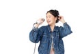 Pretty Asian young woman in jeans shirt holding microphone and singing isolated on white background. Beautiful woman smiles and Royalty Free Stock Photo