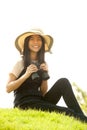 Pretty Asian young woman sit on mound seeking binoculars . Royalty Free Stock Photo