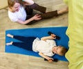 Pretty athletic mother and a young son play sports together at home. Healthy lifestyle. Royalty Free Stock Photo