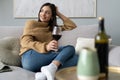 Pretty, attractive, stylish young woman sitting on couch having raised glass with red wine, examine, taste beverage Royalty Free Stock Photo