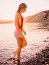 Pretty attractive woman in red swimwear on ocean with warm sunset colors Royalty Free Stock Photo