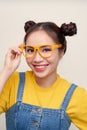 Pretty attractive young Asian woman holding her glasses with two hair-buns Royalty Free Stock Photo