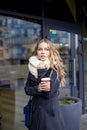 Pretty attractive young woman warming her hands on a cup of coffee Royalty Free Stock Photo