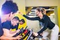 Pretty authentic female instructor with headset in fitness class exercise with group in cycling room Royalty Free Stock Photo