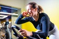 Pretty authentic female instructor with headset in fitness class exercise with group in cycling room Royalty Free Stock Photo