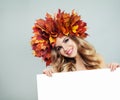 Pretty autumn woman smiling and holding empty paper board background