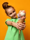 Pretty baby girl kid eating licking banana and chocolate ice cream in waffles cone Royalty Free Stock Photo