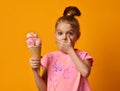 Pretty baby girl kid eating licking banana and strawberry ice cream in waffles cone Royalty Free Stock Photo