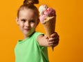 Pretty baby girl kid eating licking banana and strawberry ice cream in waffles cone Royalty Free Stock Photo