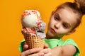 Pretty baby girl kid eating licking banana and strawberry ice cream in waffles cone Royalty Free Stock Photo